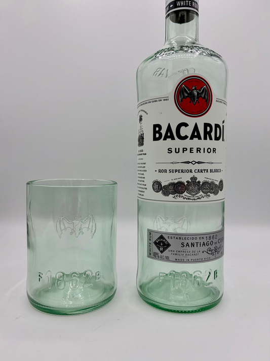 Broken Arrow Glass Recycling upcycled Bacardi bottle tumbler with embossed bat logo next to a full Bacardi bottle.