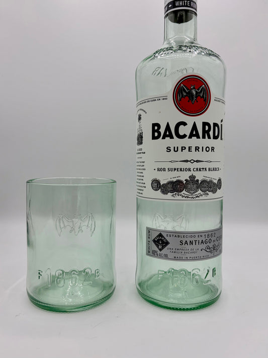 Broken Arrow Glass Recycling upcycled Bacardi tumbler glass with embossed bat logo next to a matching glass bottle.